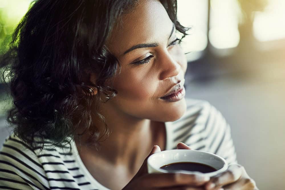 woman drinking espresso deep in thought